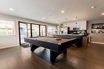 a pool table in a living room with a kitchen at Aero Apartments, Tacoma